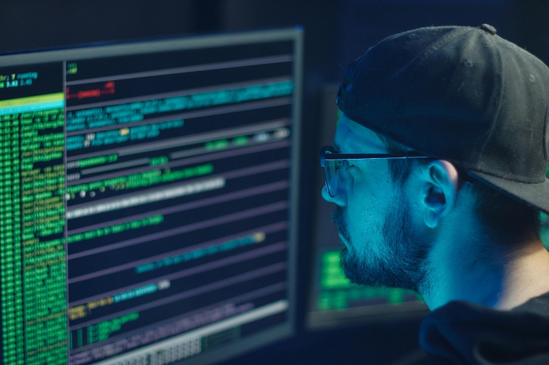 a man setting in front of computer screen checking some cyber security issues