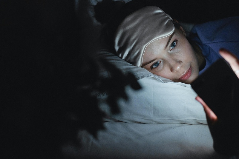 a kid is using screen mobile in sleeping time