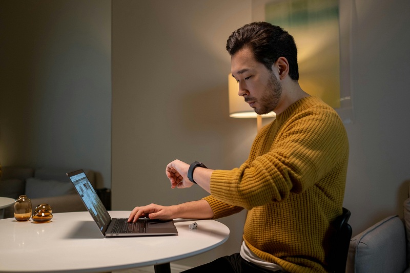 a man busy on laptop meanwhile watching time